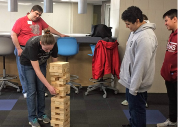 An AMP mentor is pictured, participating in a game of Jenga during a 2019 in-person session of the program